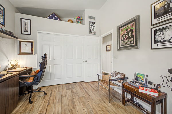 Inviting guest bedroom with plantation shutters, durable tile flooring, and plenty of natural light. A flexible room that offers comfort for family, visitors, or remote work.