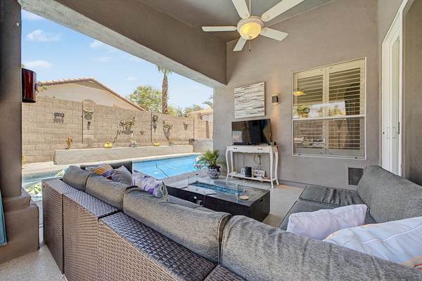 Inviting covered patio overlooking the private pool, complete with ceiling fan and comfortable outdoor seating. An ideal setting for relaxing, entertaining, and enjoying outdoor living in Mesa.