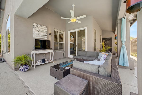 Spacious covered patio complete with ceiling fan, outdoor television, comfortable seating, and easy access to the pool. An ideal setting for entertaining guests or enjoying peaceful evenings outdoors in Mesa.