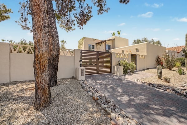 The attractive gated entrance and paved walkway lead into a peaceful private courtyard, creating a warm welcome while enhancing both security and curb appeal for this exceptional Scottsdale property.