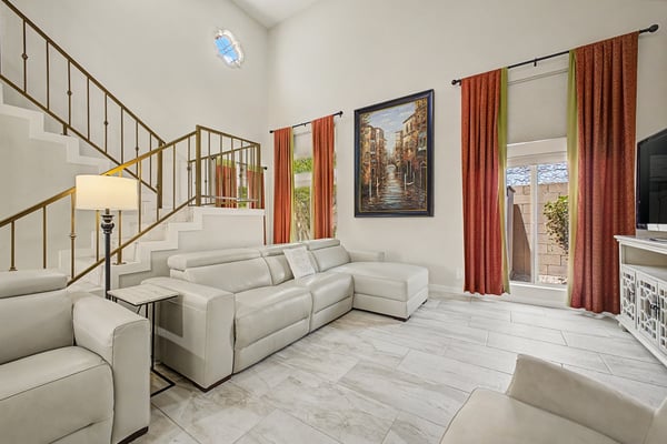 The dramatic great room showcases soaring ceilings, updated tile flooring, oversized windows, and a spacious open design ideal for entertaining and everyday living in this beautifully updated Scottsdale home.