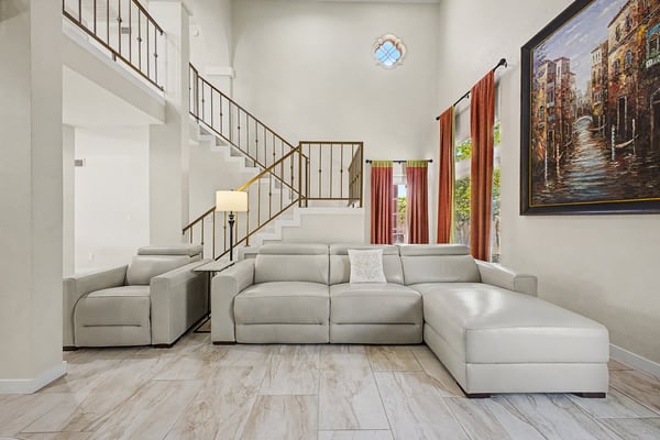 Bright, open living spaces feature impressive ceiling heights, updated flooring, and expansive windows that fill the home with natural light while creating a comfortable setting for family and guests.
