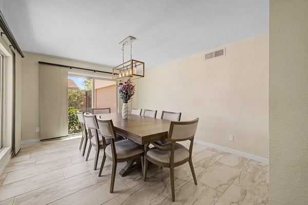 This inviting dining room offers generous seating, stylish lighting, updated flooring, and direct access to the patio, making it ideal for everyday meals and entertaining family and friends.