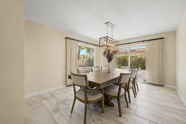 Filled with natural light, this spacious dining room features large sliding doors leading to the backyard patio, creating seamless indoor-outdoor living and an ideal setting for entertaining.