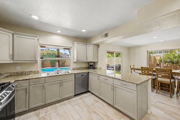 Designed for entertaining, this spacious kitchen features abundant granite counter space, stainless steel appliances, updated cabinetry, and an open layout connecting seamlessly with nearby living and dining areas.