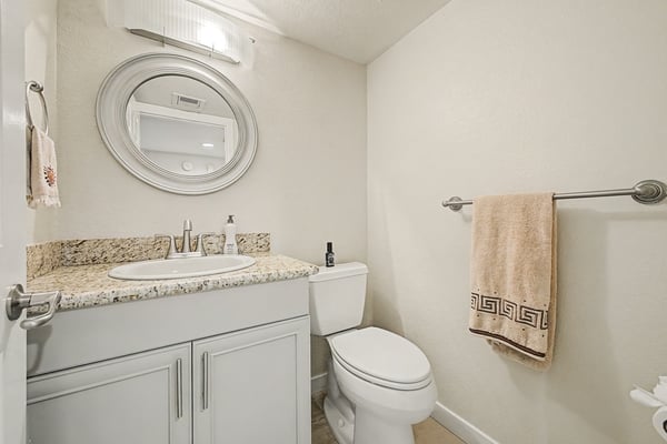 This updated guest bathroom features a granite vanity, modern fixtures, and a bright contemporary design. Conveniently located on the main level for guests and daily use.