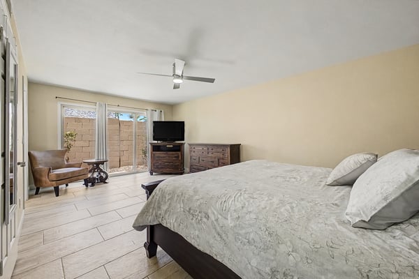 Spacious primary suite with updated tile flooring, ceiling fan, abundant natural light, and direct outdoor access. A peaceful retreat designed for comfort, privacy, and relaxation in Scottsdale.