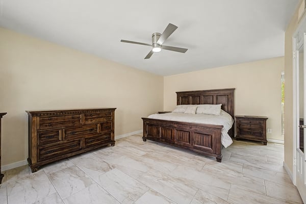 This generous primary bedroom offers plenty of room for large furnishings, updated flooring, neutral finishes, and a ceiling fan. A comfortable owner's retreat designed for everyday luxury and relaxation.