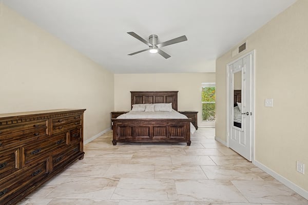 The primary bedroom offers a spacious layout with updated flooring, modern ceiling fan, abundant natural light, and room for additional seating or furnishings. An inviting owner's retreat in Scottsdale.