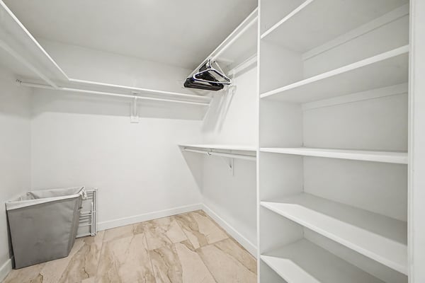 Organized walk-in closet featuring extensive shelving, hanging space, and convenient built-in storage. An ideal solution for keeping wardrobes and accessories neatly arranged.