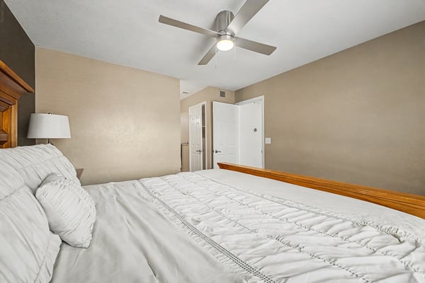 Inviting secondary bedroom with wood-look flooring, ceiling fan, neutral d cor, and generous space for guests or family. A bright and comfortable room within this Scottsdale home.