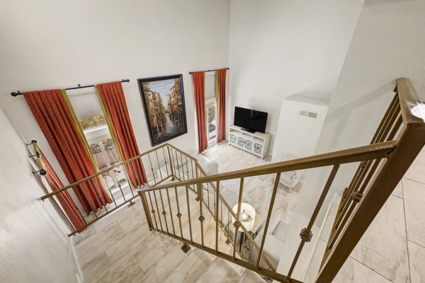 Elevated perspective showcasing the dramatic two-story great room with soaring ceilings, oversized windows, and abundant natural light. A striking architectural feature of this Scottsdale property.