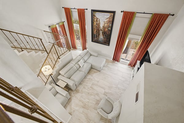 Bird's-eye view of the open-concept great room highlighting soaring ceilings, expansive windows, and upgraded flooring. Bright, spacious living designed for entertaining and everyday comfort.