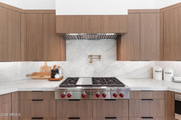 Professional-grade Wolf gas cooktop highlighted by sleek quartz countertops, custom cabinetry, designer backsplash, and premium finishes. A chef-inspired centerpiece for this beautifully remodeled Scottsdale home.