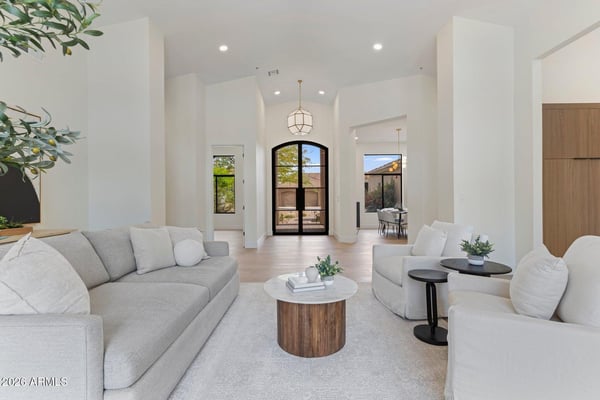 Spacious living room featuring high ceilings, abundant natural light, wide-plank flooring, and modern finishes. The open design creates a warm and comfortable setting for everyday living.