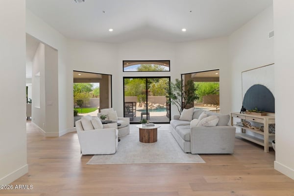 Beautiful great room overlooking the backyard through oversized windows and sliding glass doors. The seamless connection between indoor and outdoor living enhances the home's luxurious Scottsdale lifestyle.