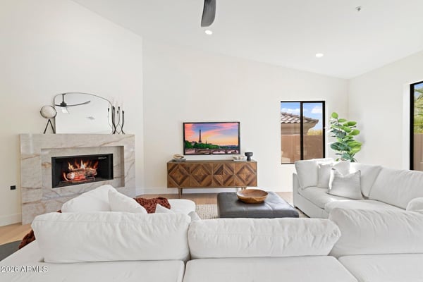 Inviting living room featuring a sleek fireplace, modern finishes, and expansive windows that fill the space with natural light. An ideal setting for relaxing or entertaining guests.