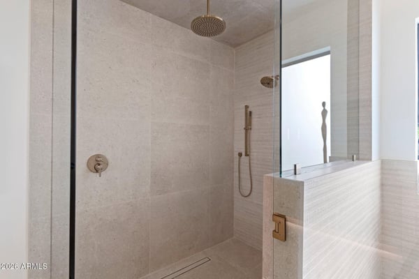 Oversized walk-in shower with premium tile finishes, frameless glass enclosure, rainfall showerhead, and luxury fixtures. Designed to deliver a relaxing spa-like experience.
