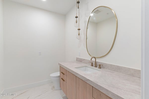 Elegant guest bathroom with quartz counters, custom cabinetry, designer lighting, and upscale hardware. Every detail reflects the exceptional craftsmanship found throughout this Scottsdale residence.