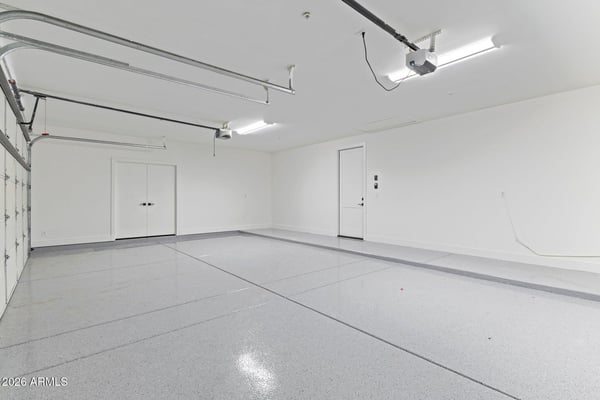 Clean, oversized garage featuring durable epoxy flooring, generous storage space, and room for multiple vehicles. A practical upgrade that enhances everyday living in this Scottsdale property.