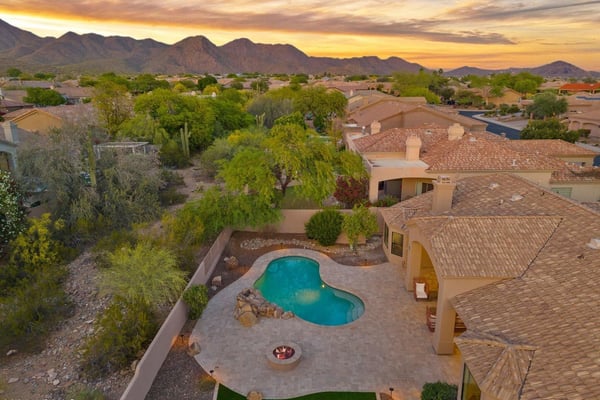 Elevated aerial view highlighting the pool, spacious patio, mature desert landscaping, and surrounding mountain scenery that make this Scottsdale property truly exceptional.