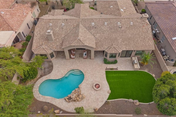 Overhead view highlighting the custom pool, expansive patio, fire pit, covered outdoor living area, artificial turf, and thoughtfully designed backyard in Scottsdale.