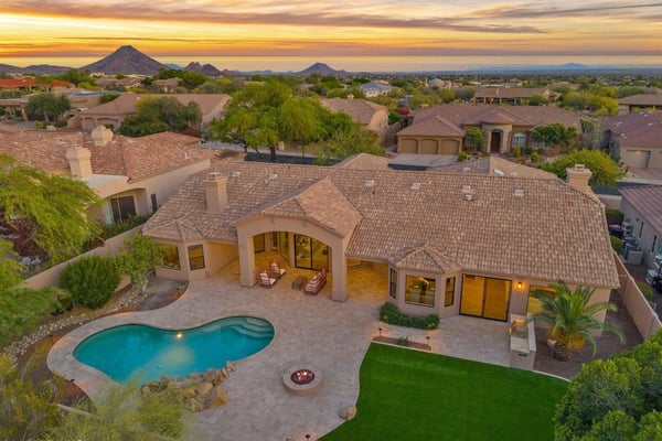 Stunning overhead view of the backyard featuring a sparkling swimming pool, custom outdoor entertaining areas, built-in BBQ, expansive travertine patio, and professionally landscaped grounds in Scottsdale.