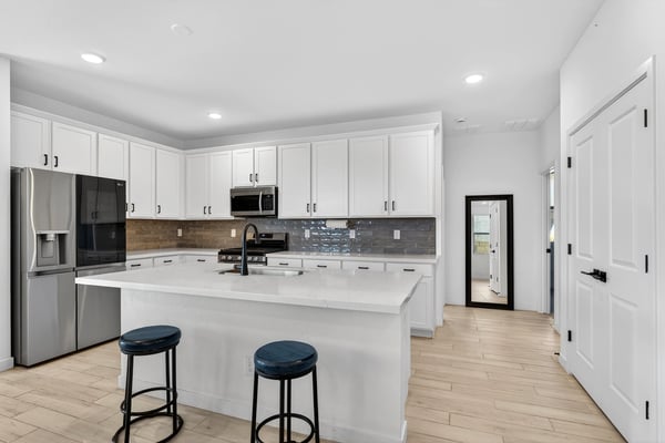 Cook with ease in this beautifully designed kitchen featuring stainless steel appliances, quartz countertops, stylish cabinetry, subway tile backsplash, and an oversized center island.