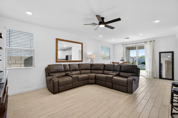 The expansive great room offers an open layout with durable wood-look flooring, recessed lighting, ceiling fan, and flexible space for relaxing, entertaining, and everyday living.