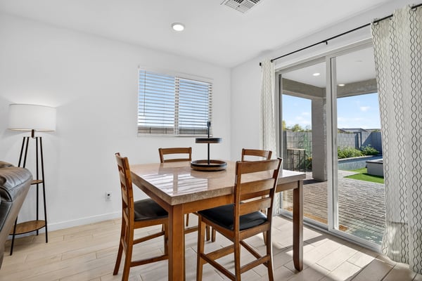 Sliding glass doors create an effortless transition from the dining area to the covered patio and professionally finished backyard, making indoor-outdoor entertaining simple and enjoyable.