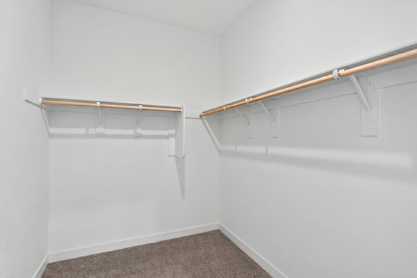 This generously sized walk-in closet provides extensive hanging space and storage, making it easy to organize your wardrobe while complementing the spacious primary suite.