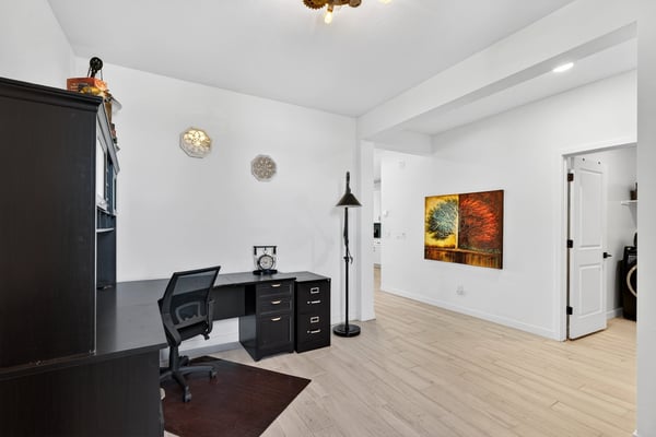 This dedicated office provides an ideal work-from-home environment with durable wood-look tile flooring, generous natural light, and versatile space for business or hobbies.