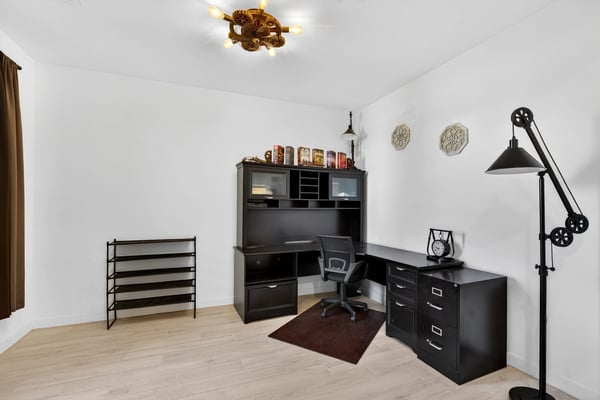 This dedicated office offers generous workspace, wood-look tile flooring, and plenty of room for working from home, studying, or creating a personalized flex space.