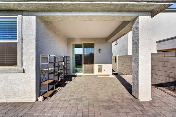 Covered patio with paver flooring and sliding glass door access creates an ideal extension of the great room for outdoor dining, entertaining, and relaxing.