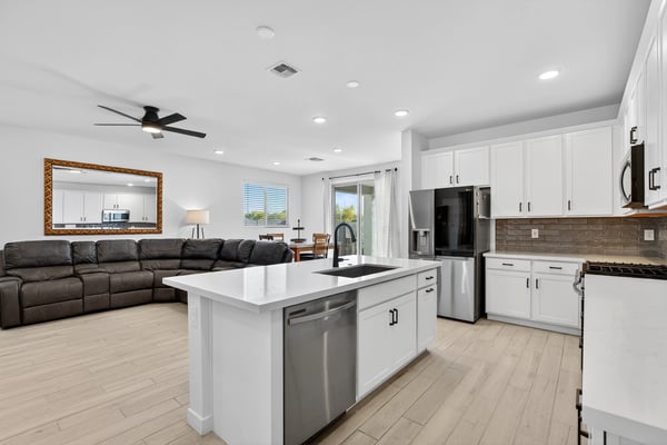 Designed for modern living, this beautiful kitchen features quartz countertops, stainless steel appliances, a large center island, abundant cabinetry, and an open layout connecting seamlessly to the great room.