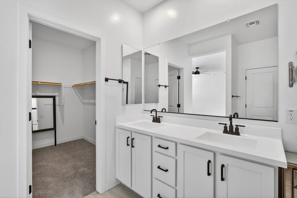 Enjoy added convenience with a spacious dual-sink vanity, modern cabinetry, quartz countertops, and direct access to the large walk-in closet in this thoughtfully designed ensuite.