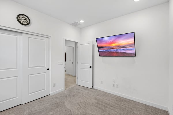 This comfortable secondary bedroom offers soft carpeting, neutral finishes, recessed lighting, and flexible space suitable for guests, children, or a private office in Surprise.