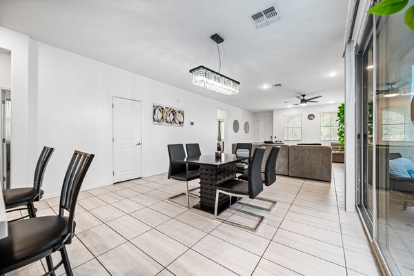 Dining area opening directly into the spacious great room, creating an ideal space for entertaining and family gatherings. Large windows and patio access enhance the bright, open feel.