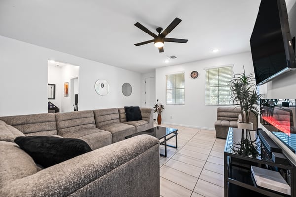 Spacious family room featuring contemporary finishes, recessed lighting, ceiling fan, and an electric fireplace. A comfortable gathering place that complements the home's open-concept design.