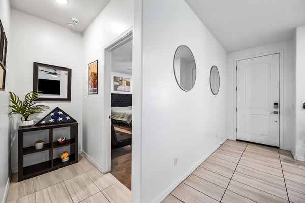 Welcoming interior hallway showcasing modern flooring and easy access to the primary bedroom and main living spaces. A thoughtfully designed layout enhances the home's functionality.
