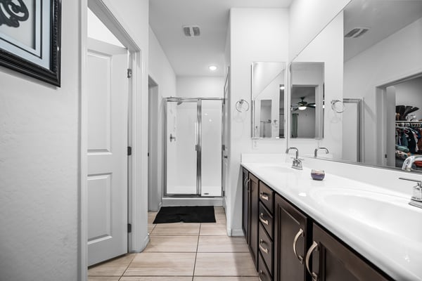 Well-appointed primary bathroom with dual sinks, walk-in shower, generous countertop space, and excellent storage. A comfortable retreat that complements the spacious primary suite.