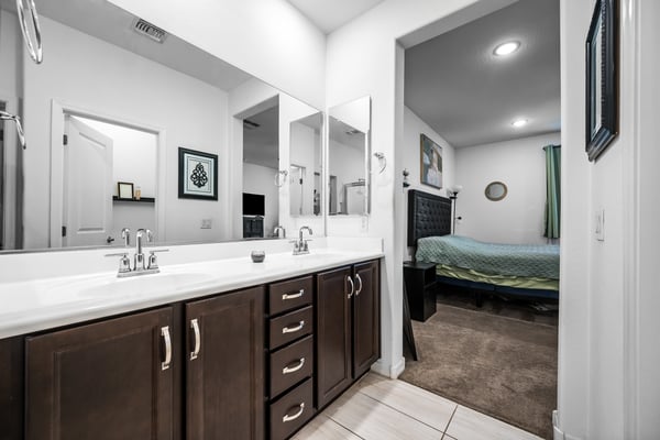 Another view of the primary bathroom highlighting the dual vanity, modern cabinetry, and seamless connection to the owner's suite. Designed for convenience and relaxation.