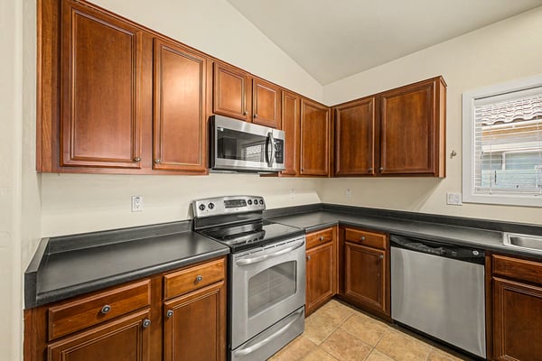 Functional kitchen featuring beautiful wood cabinetry, stainless steel appliances, abundant counter space, and plenty of storage, creating an ideal space for daily cooking and entertaining.