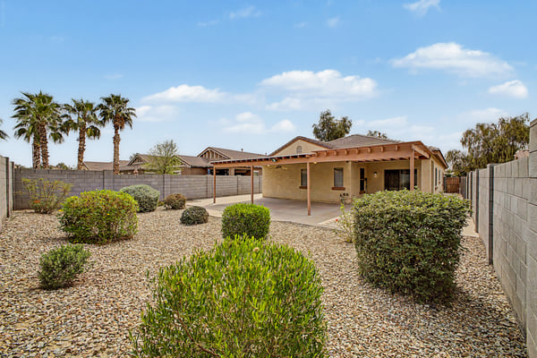 Spacious backyard designed for easy outdoor living with desert landscaping, an extended covered patio, and ample room for entertaining family and friends year-round.