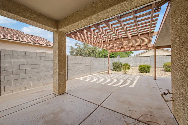 Covered backyard patio with an expansive concrete entertaining area, creating the perfect outdoor retreat for relaxing, dining, and enjoying the Arizona lifestyle.