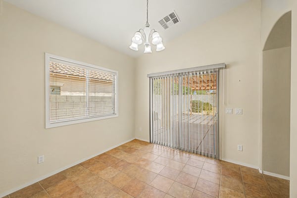 Bright dining space with large windows and sliding glass doors leading directly to the covered patio, making indoor and outdoor entertaining effortless.