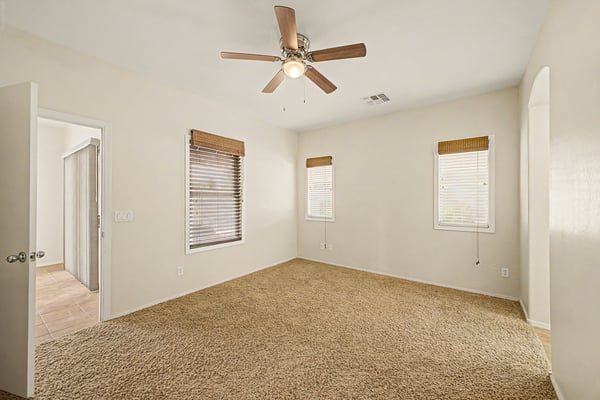 Expansive primary suite filled with natural light, neutral finishes, and comfortable living space designed for relaxation and everyday comfort.