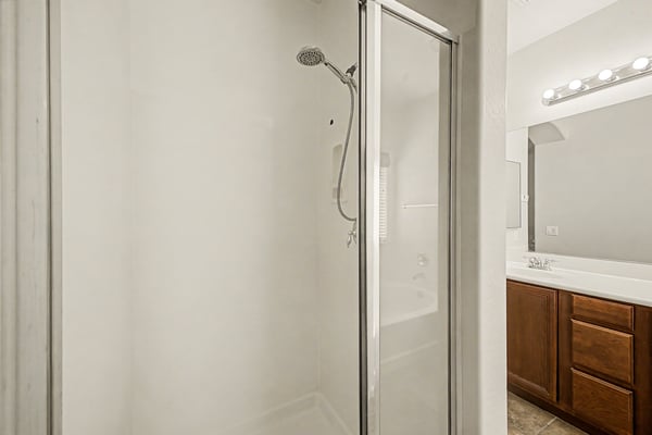 Walk-in shower with glass enclosure located within the spacious primary bathroom, providing a functional and comfortable bathing area.