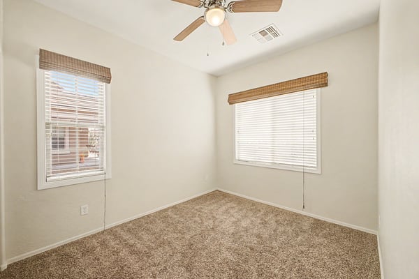 Well-sized secondary bedroom featuring soft carpeting, abundant natural light, ceiling fan, and a spacious closet for versatile everyday living.