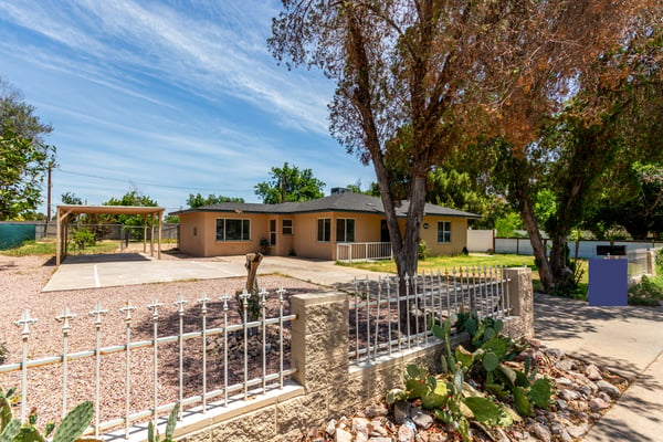 The side exterior reveals additional green space, backyard access, and mature landscaping surrounding this oversized property. Buyers will appreciate the flexibility and usable outdoor areas this Mesa home provides.